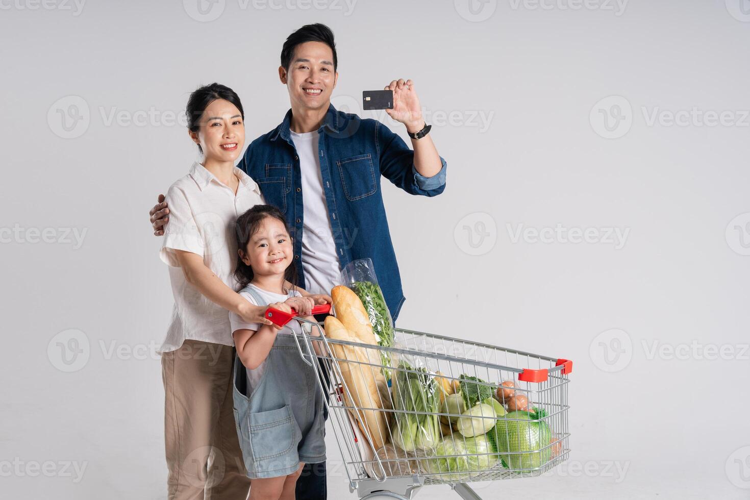 Image of Asian family pushing a supermarket cart while shopping, isolated on white background photo