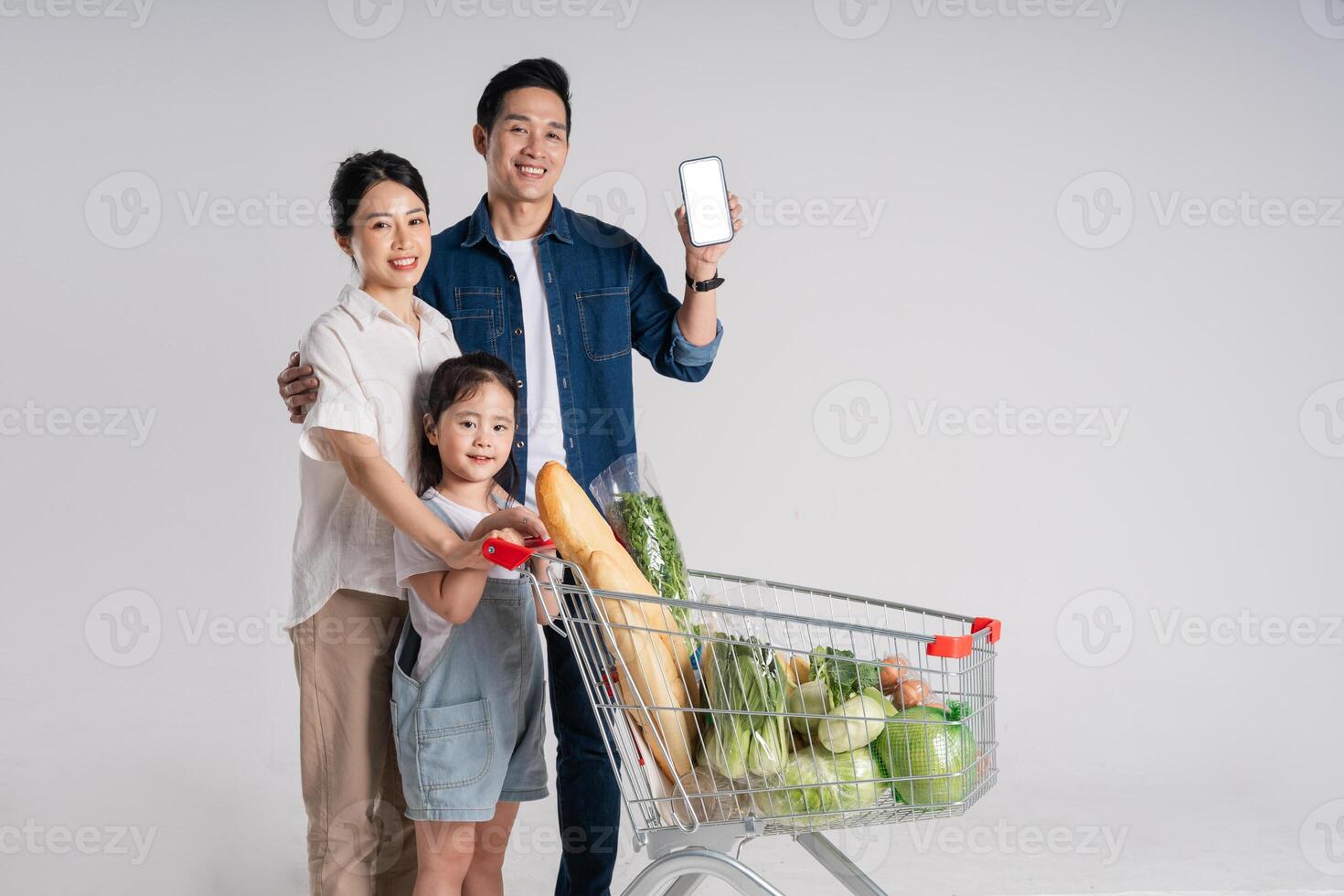 Image of Asian family pushing a supermarket cart while shopping, isolated on white background photo