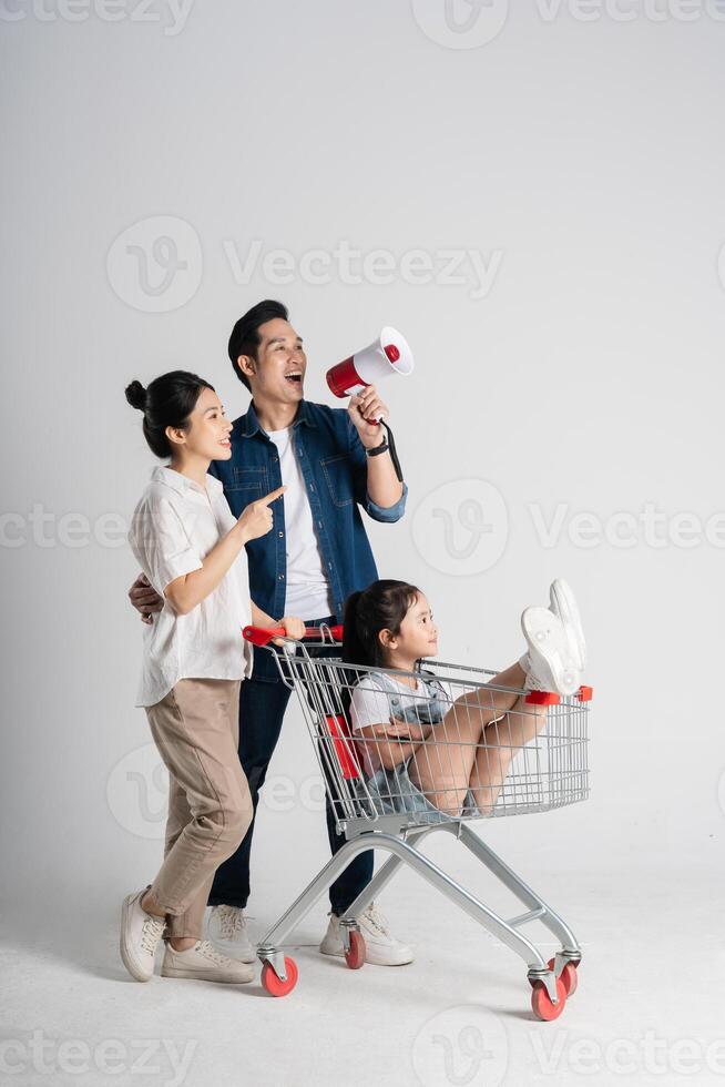 Image of Asian family pushing a supermarket cart while shopping, isolated on white background photo