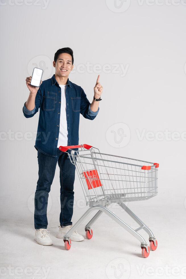 Happy smiling man pushing supermarket cart isolated on white background photo