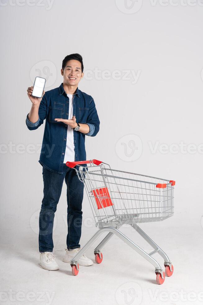 Happy smiling man pushing supermarket cart isolated on white background photo