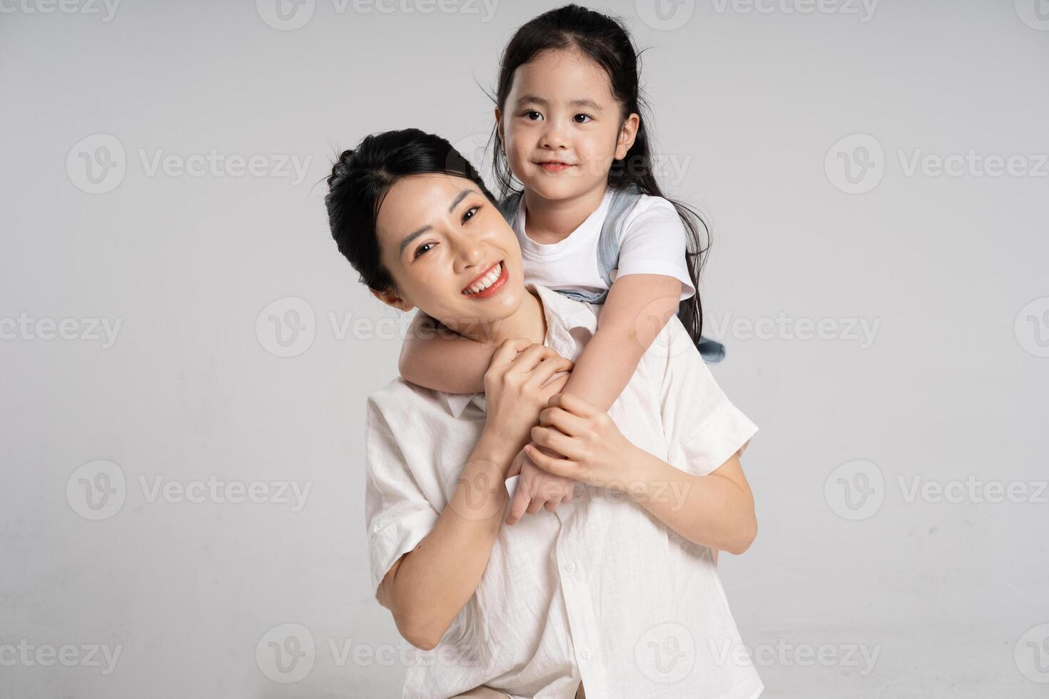 retrato de un asiático madre y hija posando en un blanco antecedentes foto