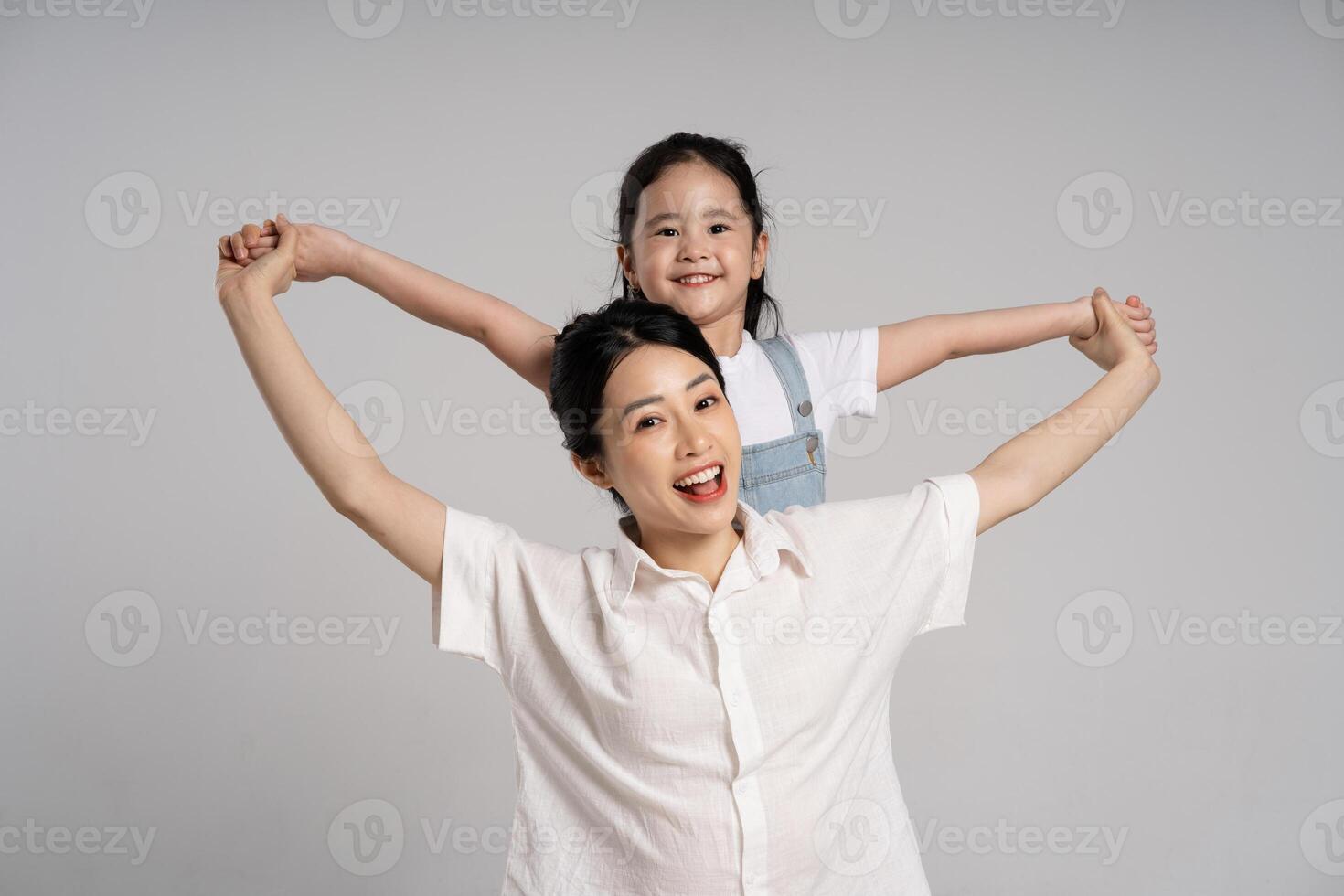 Portrait of an Asian mother and daughter posing on a white background photo
