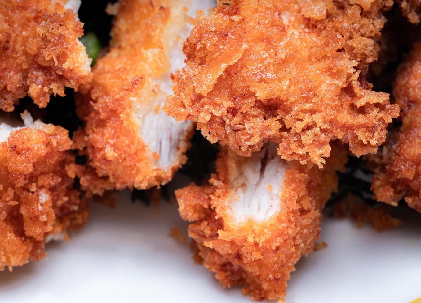 Fried Chicken Ingredients include bread crumbs. One of the most popular fried foods. Chopped or sliced fried chicken placed on a white plate. photo