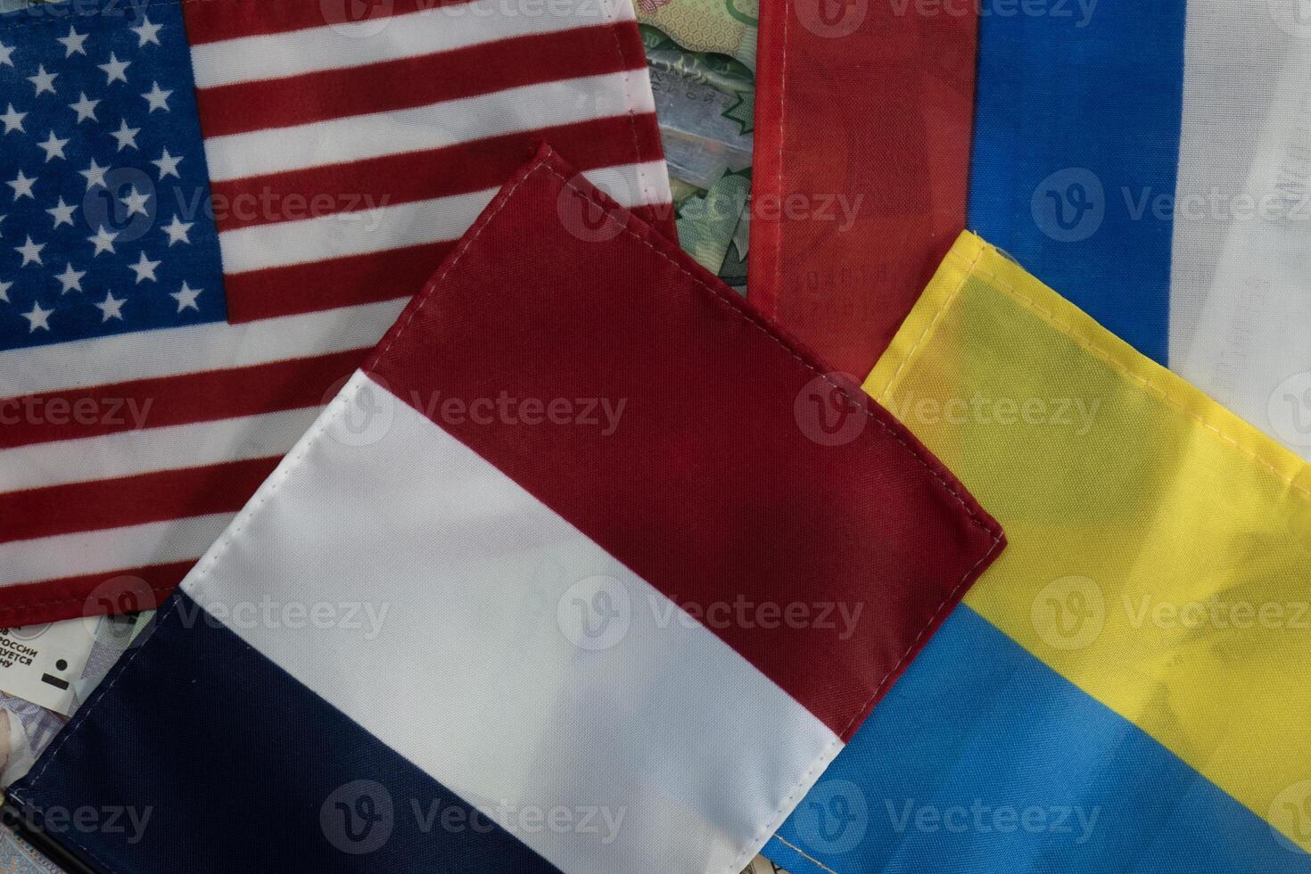 United States, French, Russian and Ukrainian flags on international currencies photo