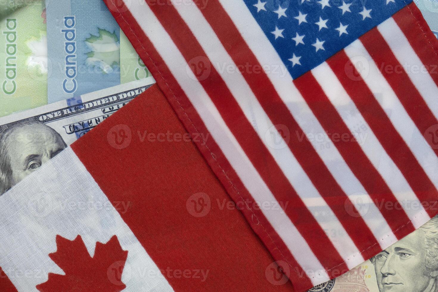 United States and Canadian flags on dollar and loonie currencies photo