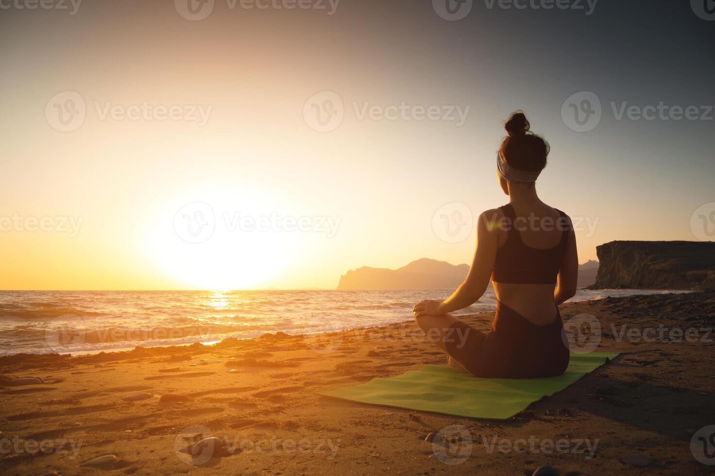 yoga mujer meditando a sereno puesta de sol o amanecer en el playa. el niña relaja en el loto posición. dedos doblada en mudras. foto