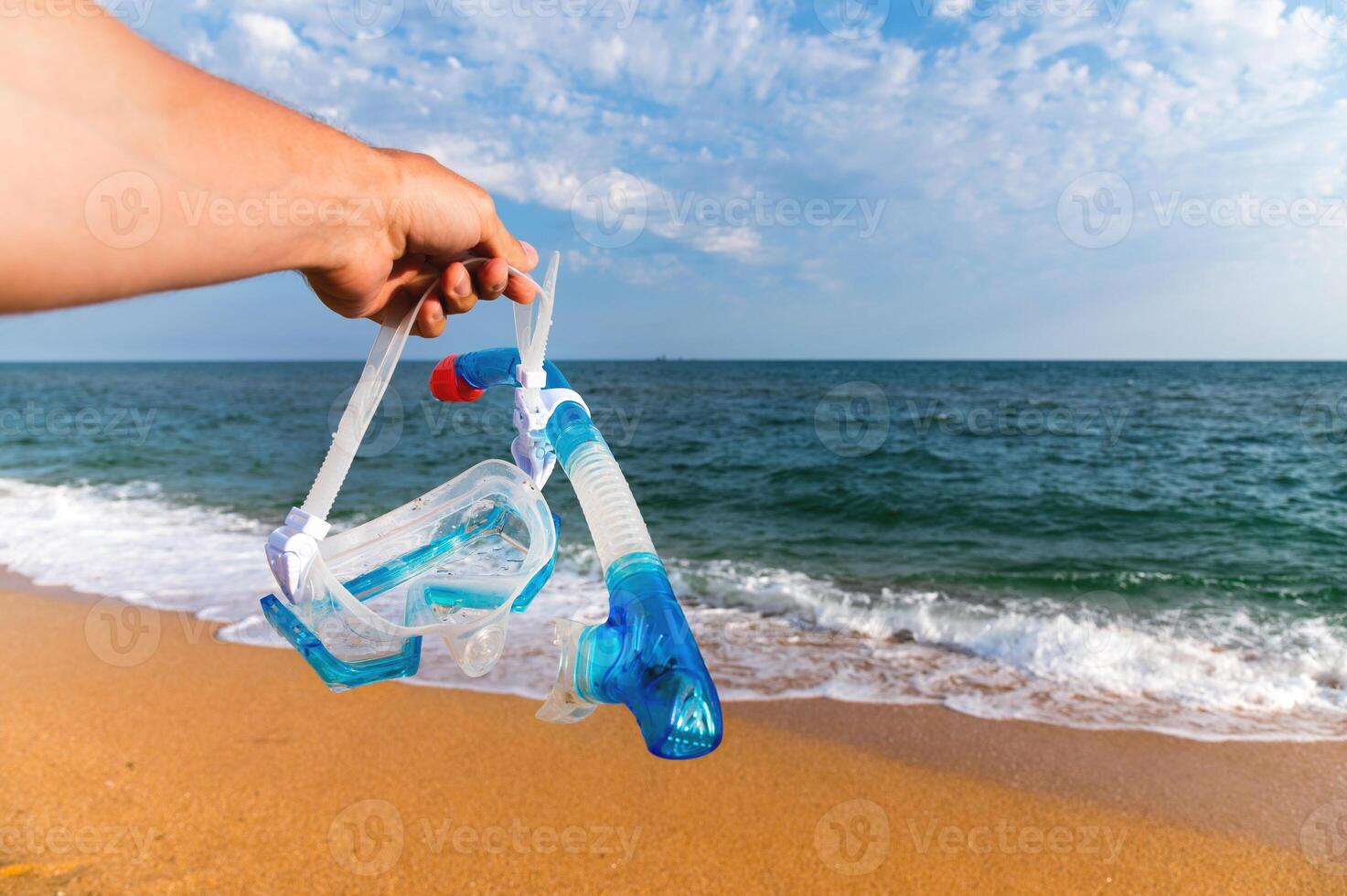 Underwater mask for snorkeling against the backdrop of sunset sandy shore and sea photo