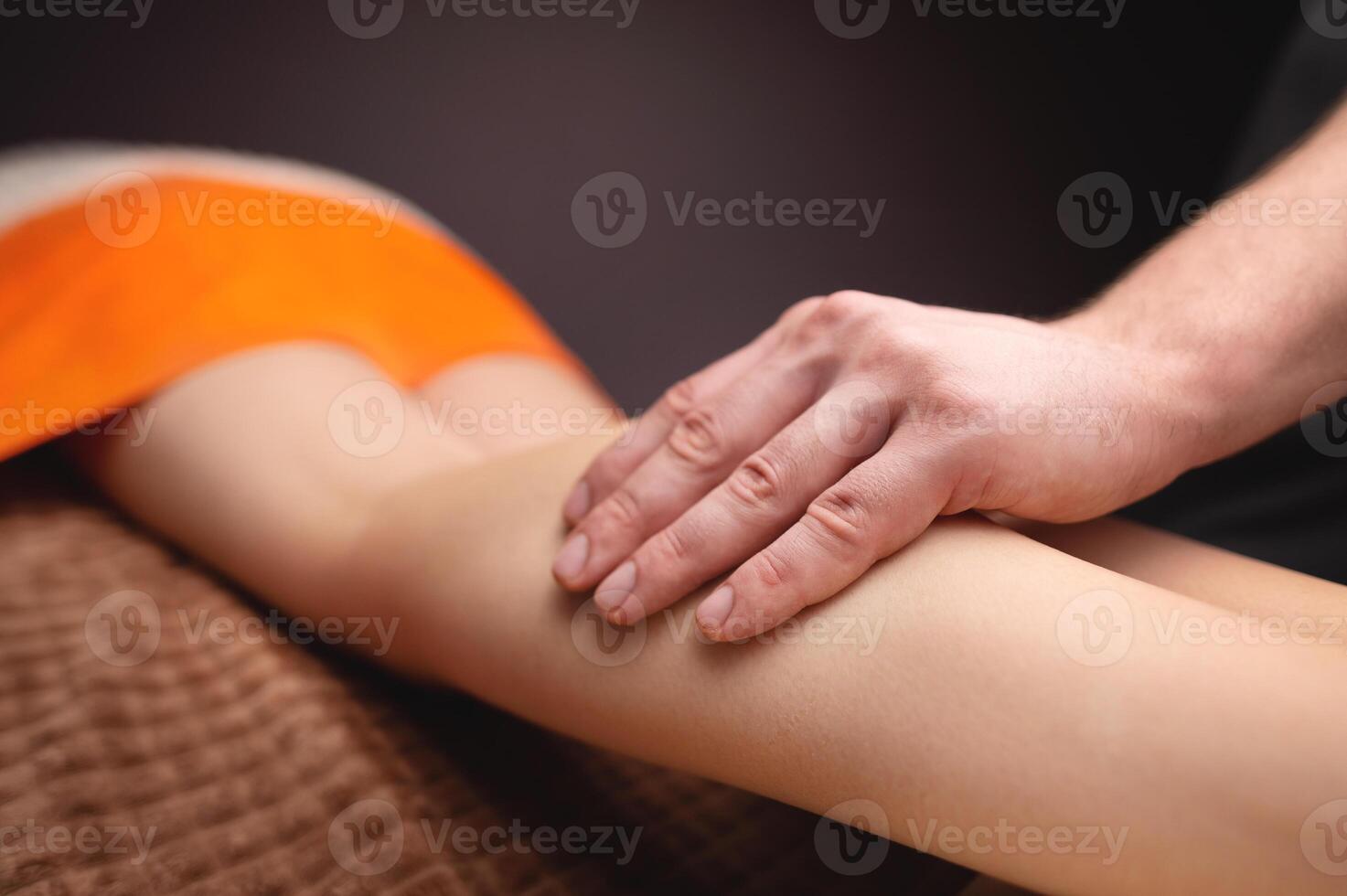 masculino manos masajear el humano becerro músculo. terapeuta aplicando presión en un mujer pierna foto