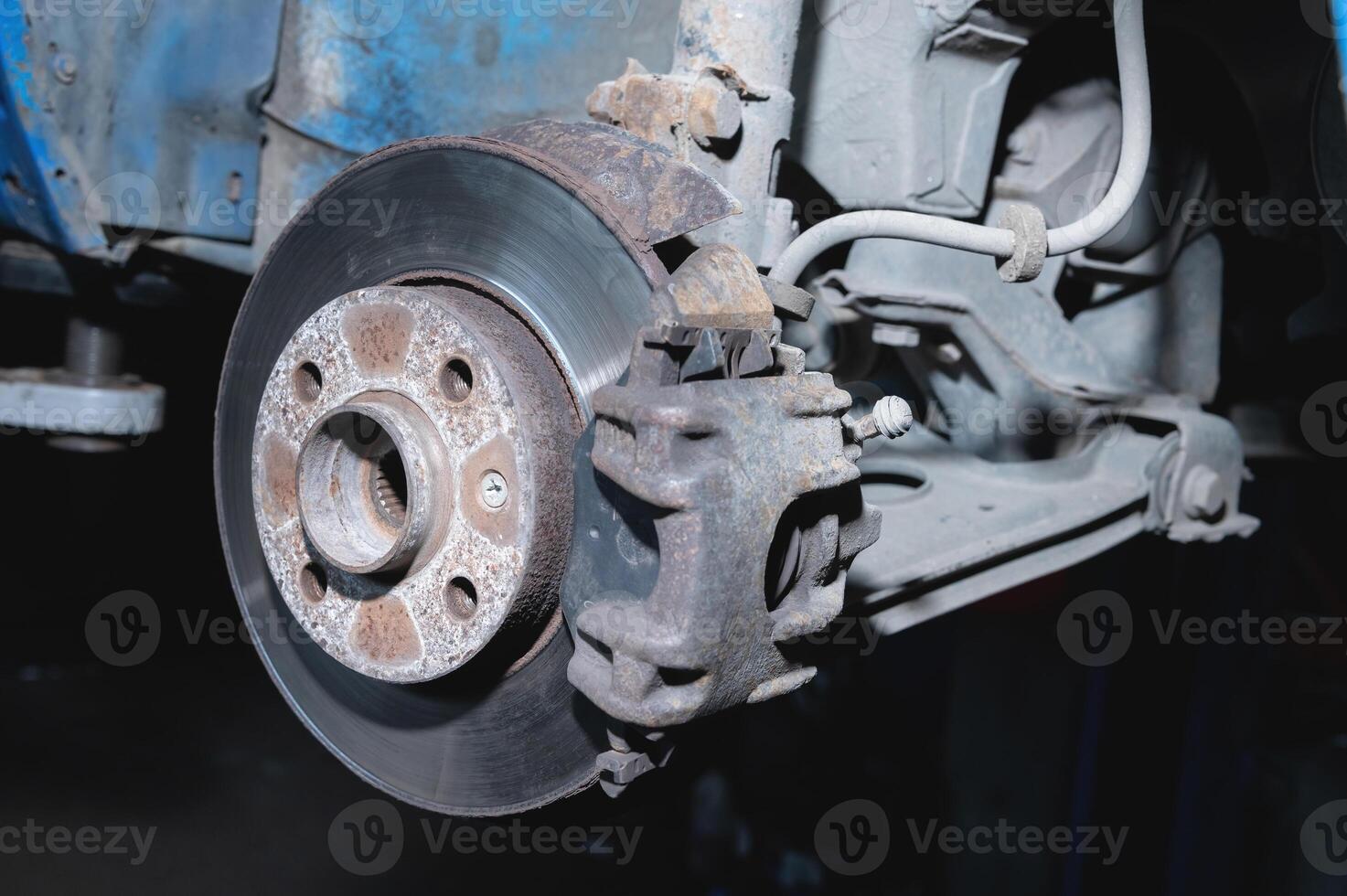 oxido proteccion y reparar de un disco roto en un Servicio centro, de cerca. frente suspensión de un antiguo coche foto