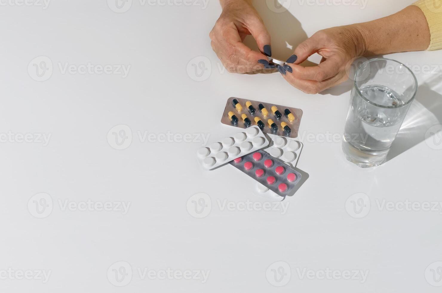 mayor mujer apertura un medicamento. de cerca de hembra manos participación paquete de pastillas, blanco antecedentes Copiar espacio. tratamiento concepto, enfermedad Jubilación foto