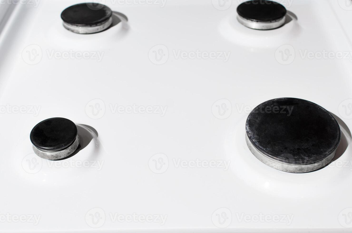 Clean white surface of the gas stove. Hotplate close-up, selective focus. Gas panel after cleaning photo