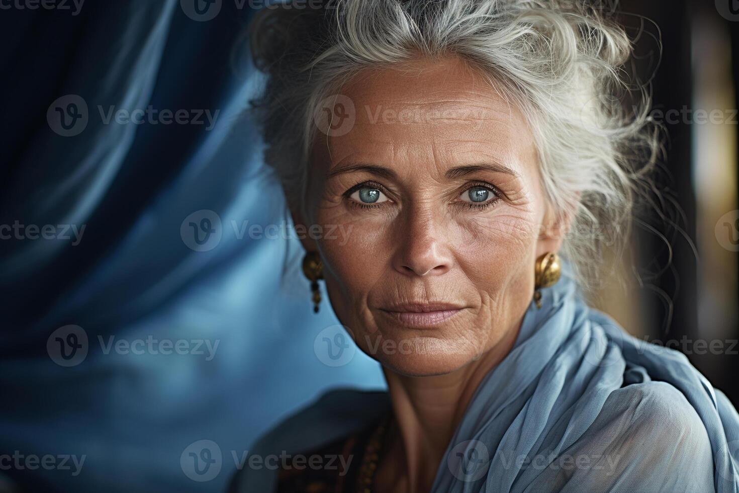 ai generado mayor feminidad, retrato de un mayor hermosa experimentado mujer con gris pelo en un azul tela antecedentes mirando a cámara foto