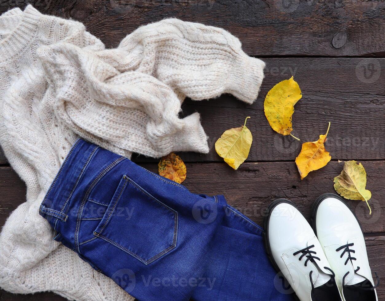 Autumn female outfit. Set of clothes, shoes and accessories on wooden background photo