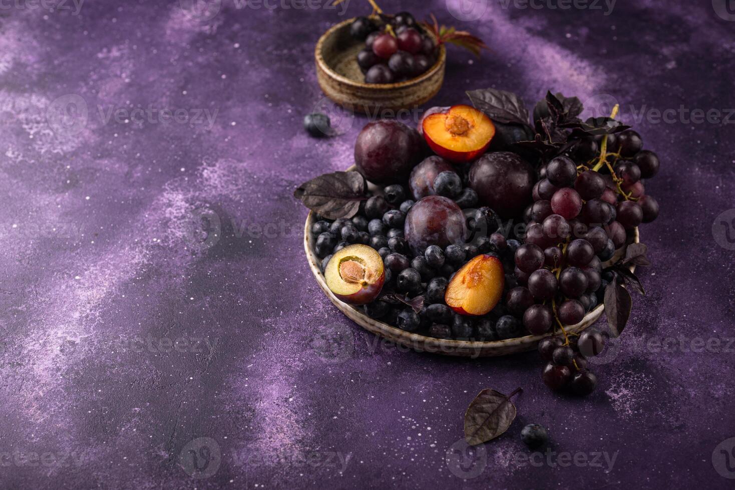 surtido de púrpura Fruta ciruela, uva, arándano y albahaca foto