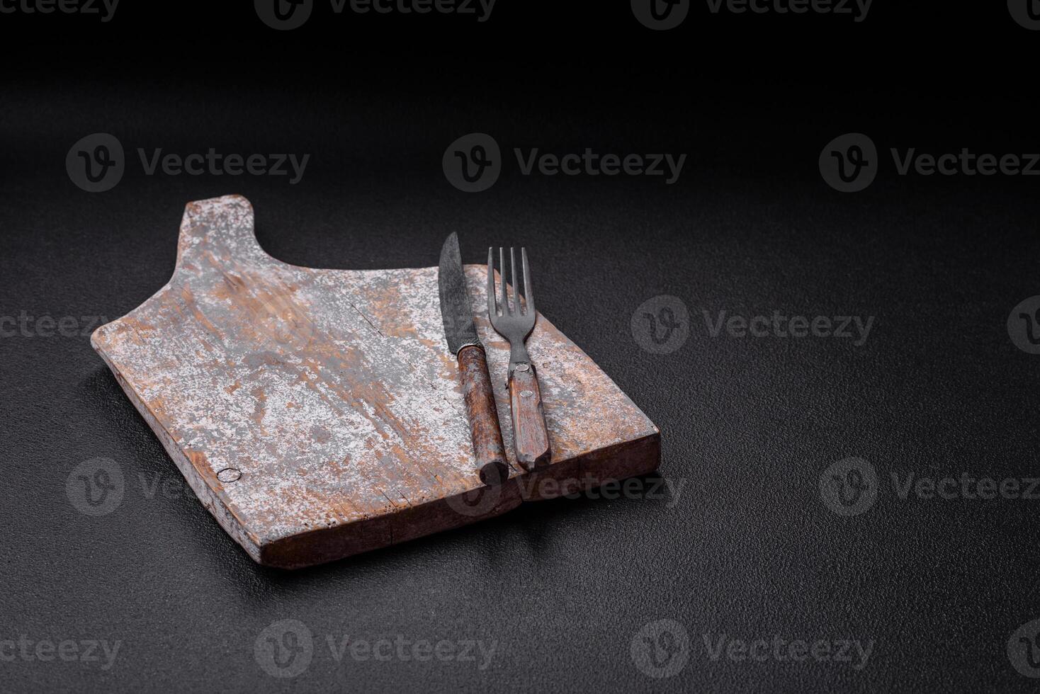 Cutlery fork, knife and spoon on a dark textured concrete background photo
