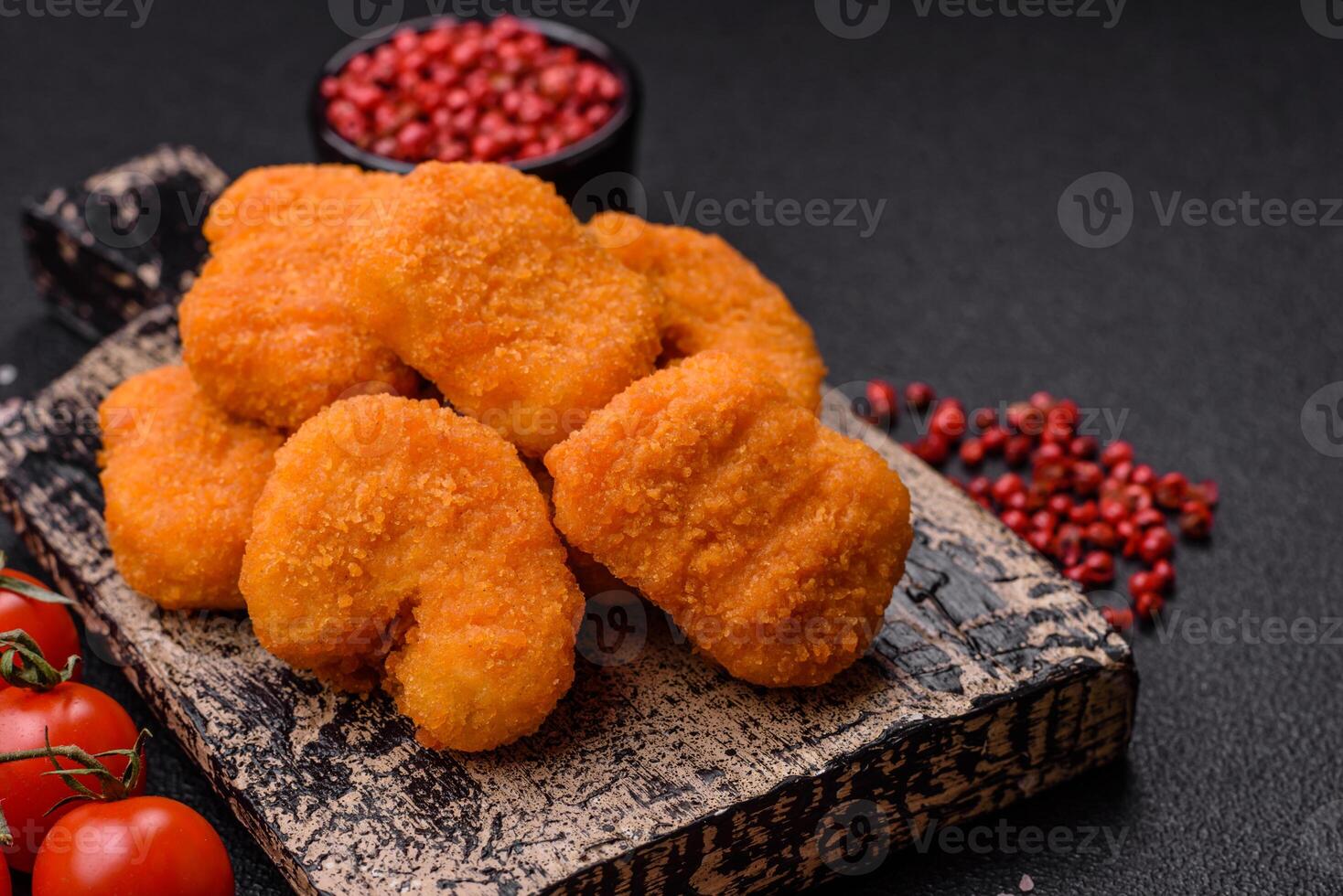 Delicious fresh crispy chicken nuggets on a dark concrete background photo