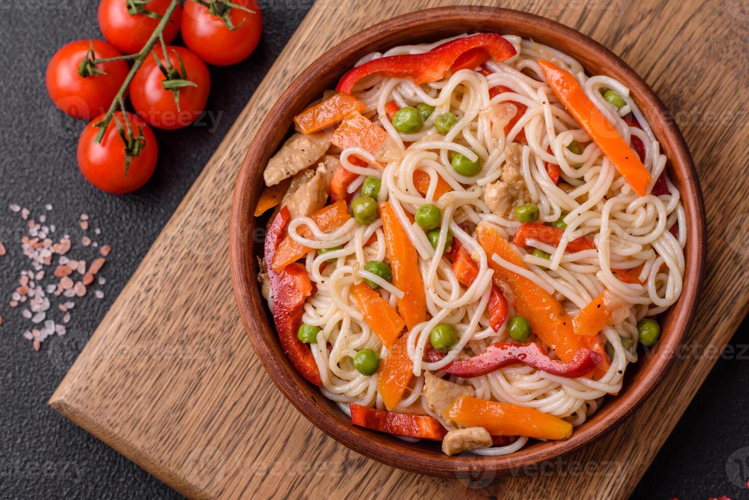 Delicious rice noodles or udon with chicken, carrots, pepper, salt, spices and herbs photo