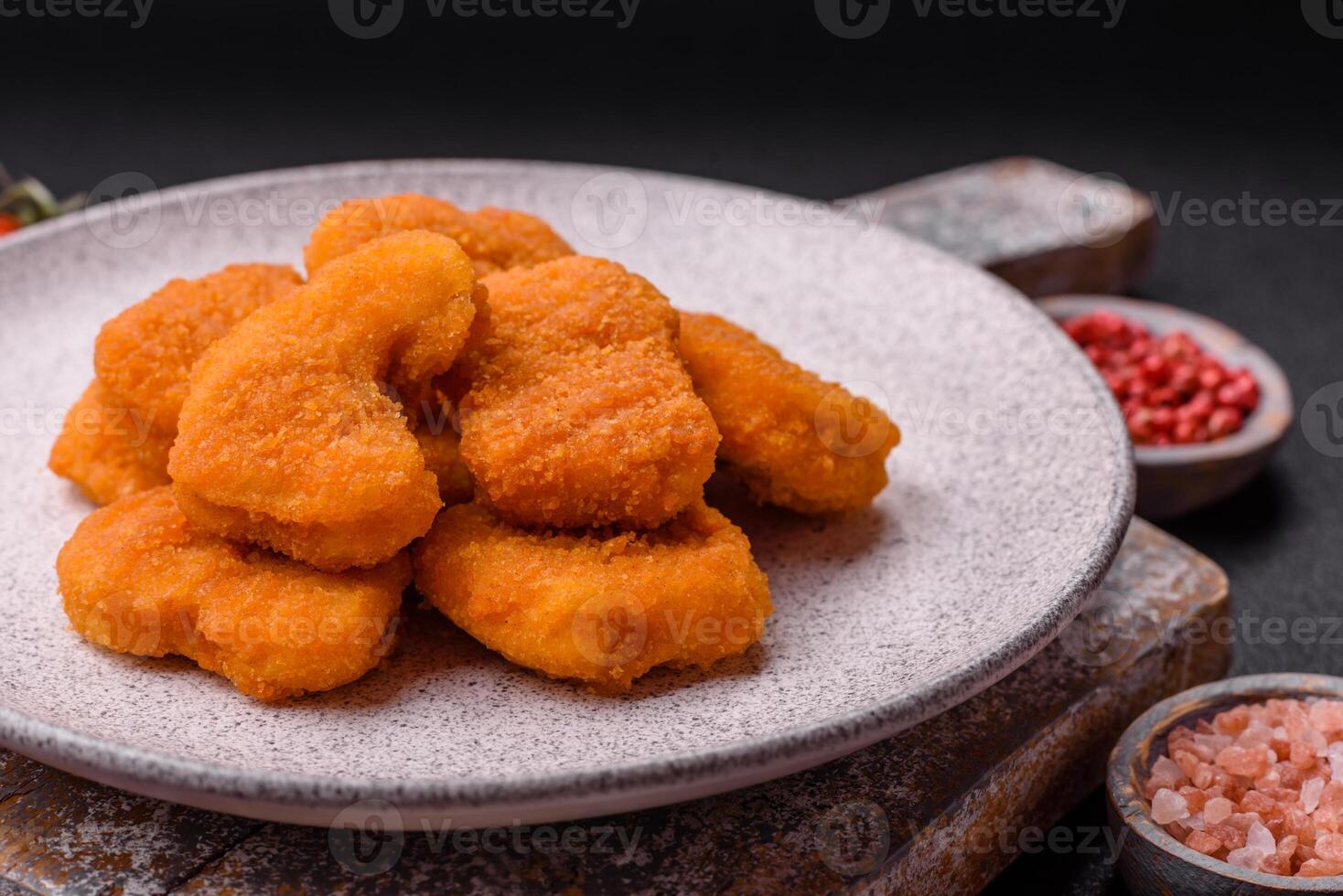 Delicious fresh crispy chicken nuggets on a dark concrete background photo