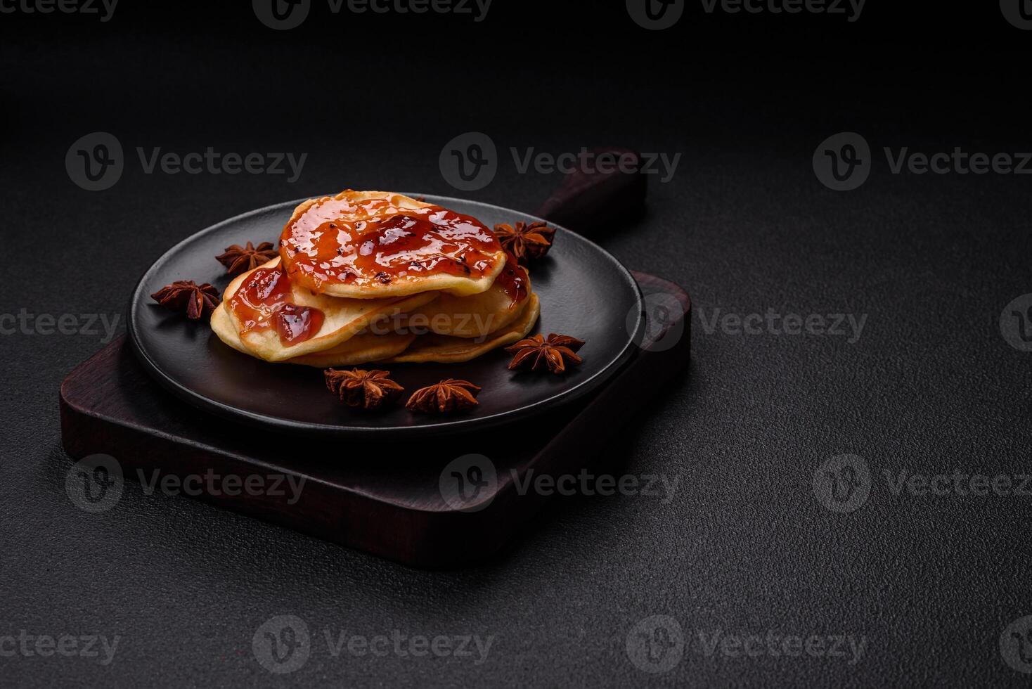 Fresh baked pancakes with delicious jam on a ceramic plate photo