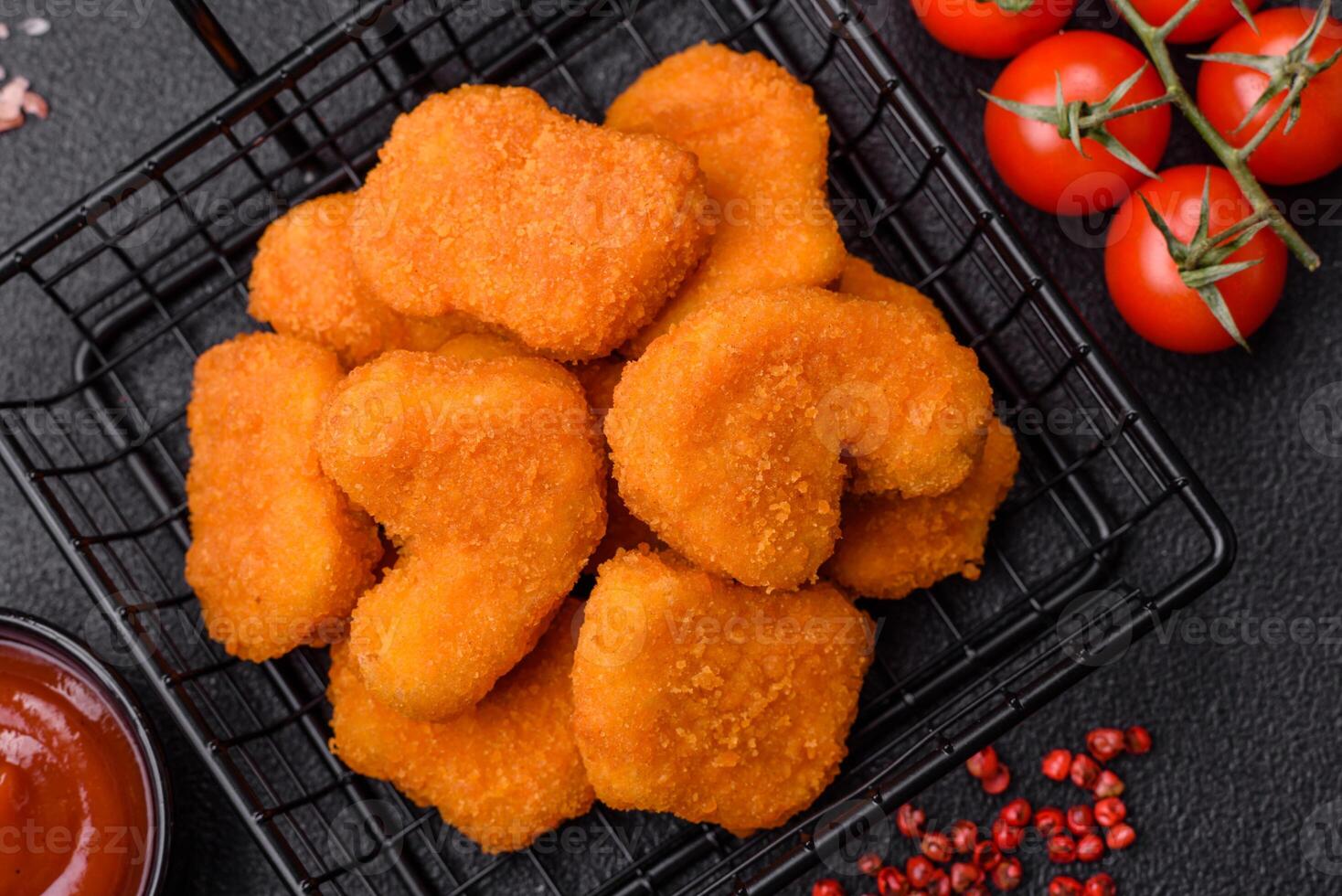 Delicious fresh crispy chicken nuggets on a dark concrete background photo