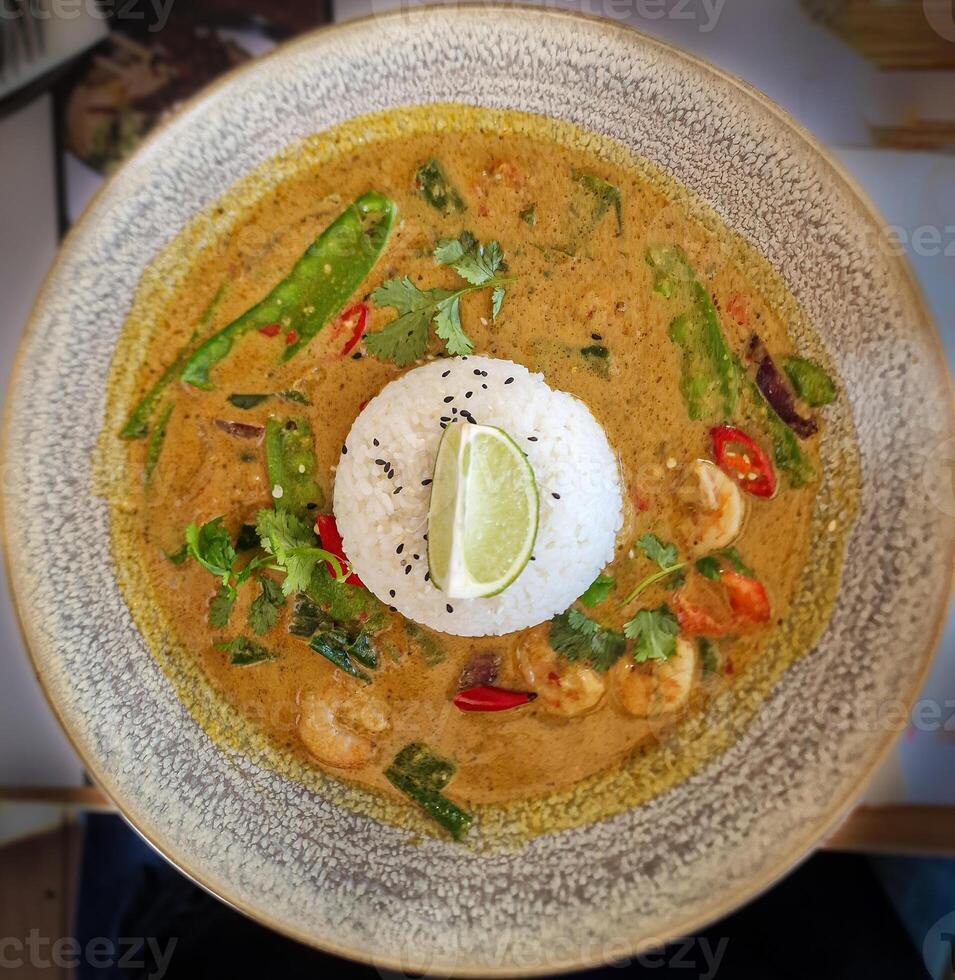 Shrimps in spicy curry sauce and rice on a plate. View from above photo