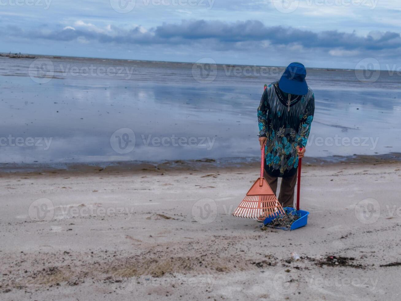 alguien quien es que lleva fuera basura limpieza ocupaciones alrededor el playa, verde tierra, costero limpiar día foto