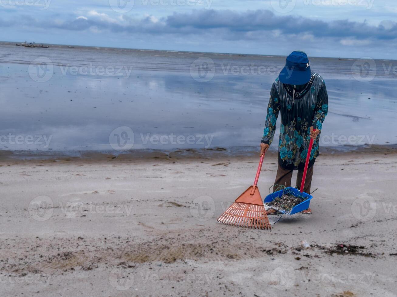 someone who is carrying out rubbish cleaning activities around the beach, green earth, coastal cleanup day photo