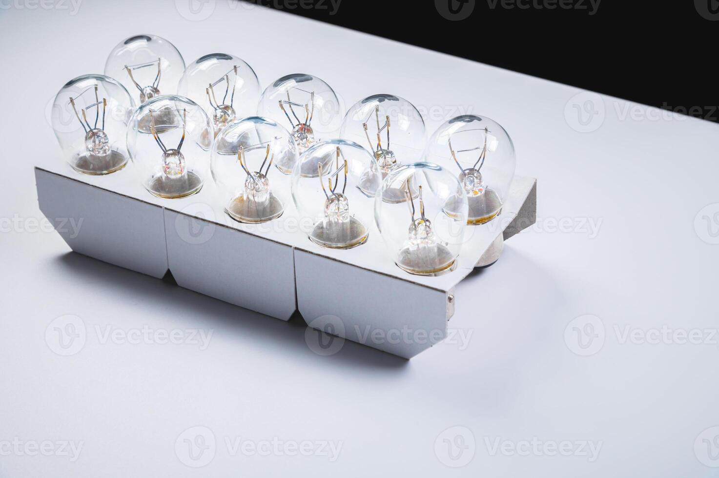 New incandescent car lamps for car sizes in paper-packed lot on a grey gradient background photo