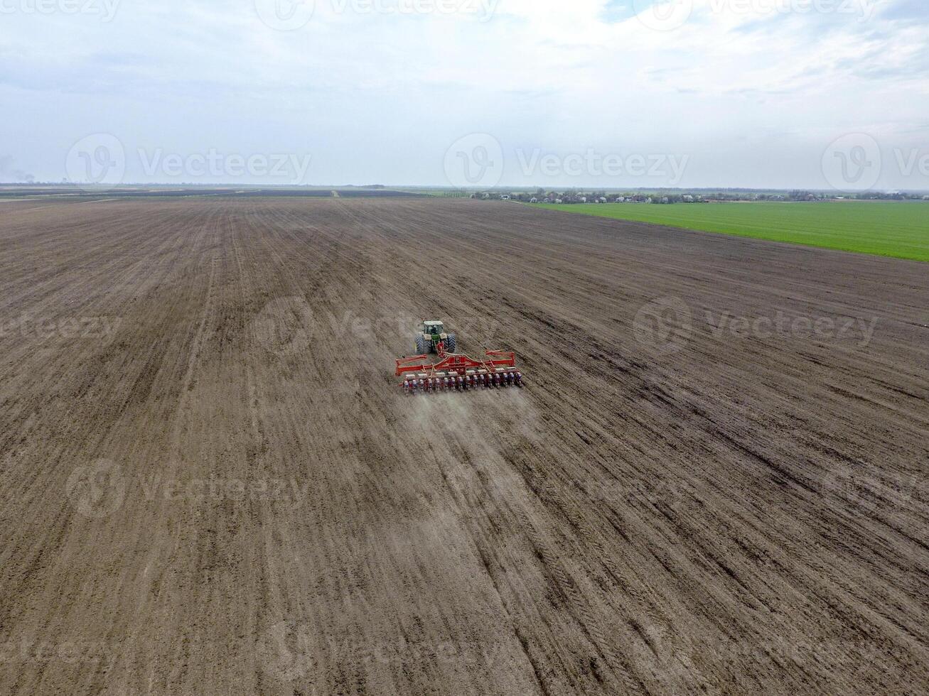 siembra de maíz. tractor con un sembradora en el campo. utilizando un sembradora para plantando maíz. foto