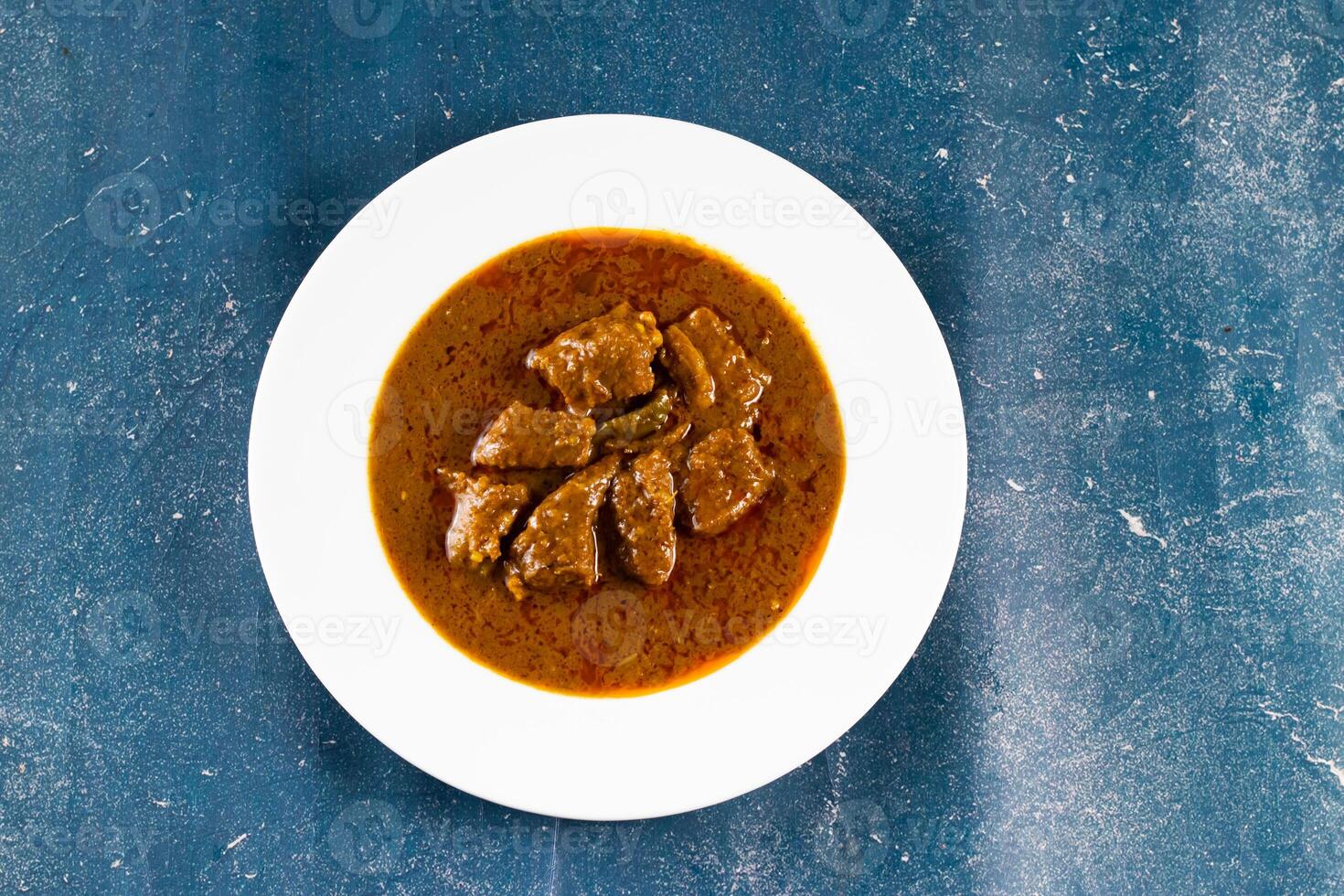Spicy beef qorma masala in a plate isolated on marble background top view of pakistani, indian food photo