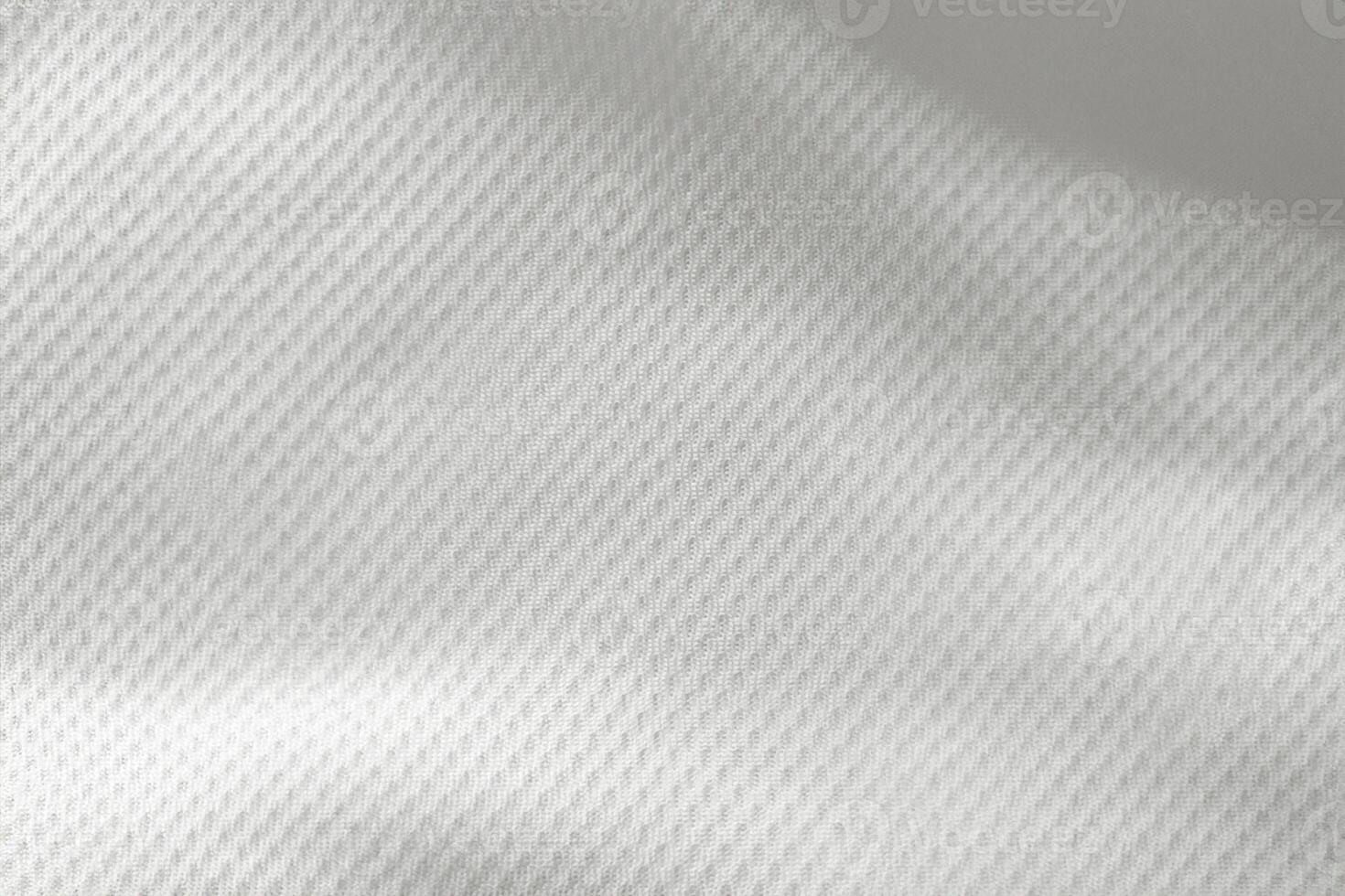 A close-up top view of the texture of a white sports fabric jersey football shirt. photo