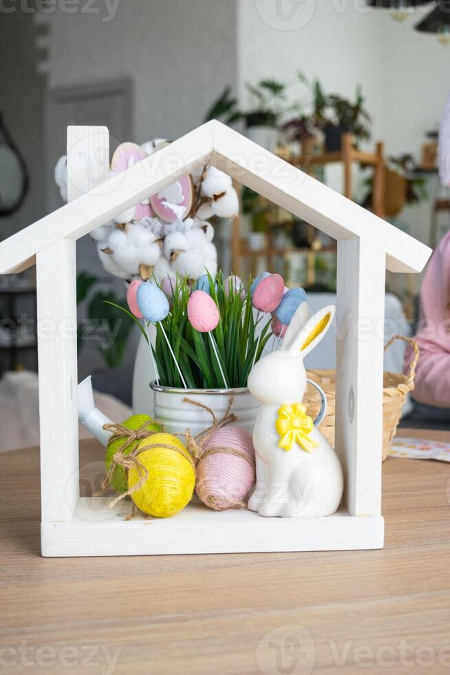 Tiny house of cozy home with Easter decor with rabbit and eggs on table of kitchen. Building, design, project, moving to new house, mortgage, insurance, rent and purchase real estate photo