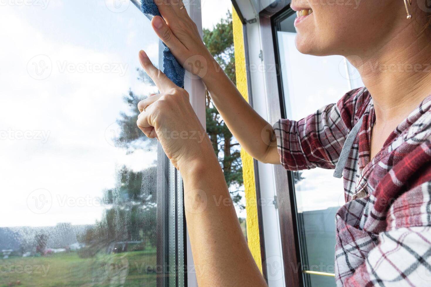 mujer a mano lavados el ventana de el casa con un trapo con rociar limpiador y fregona dentro el interior con blanco cortinas restaurar orden y limpieza en el primavera, limpieza servise foto