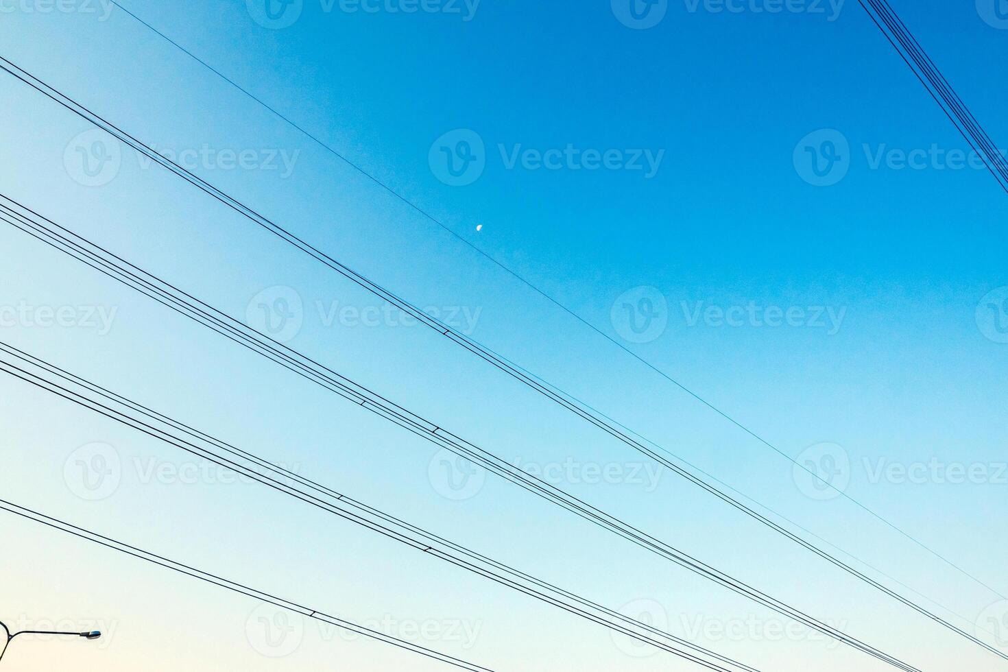 The electrical cables cross the blue sky photo