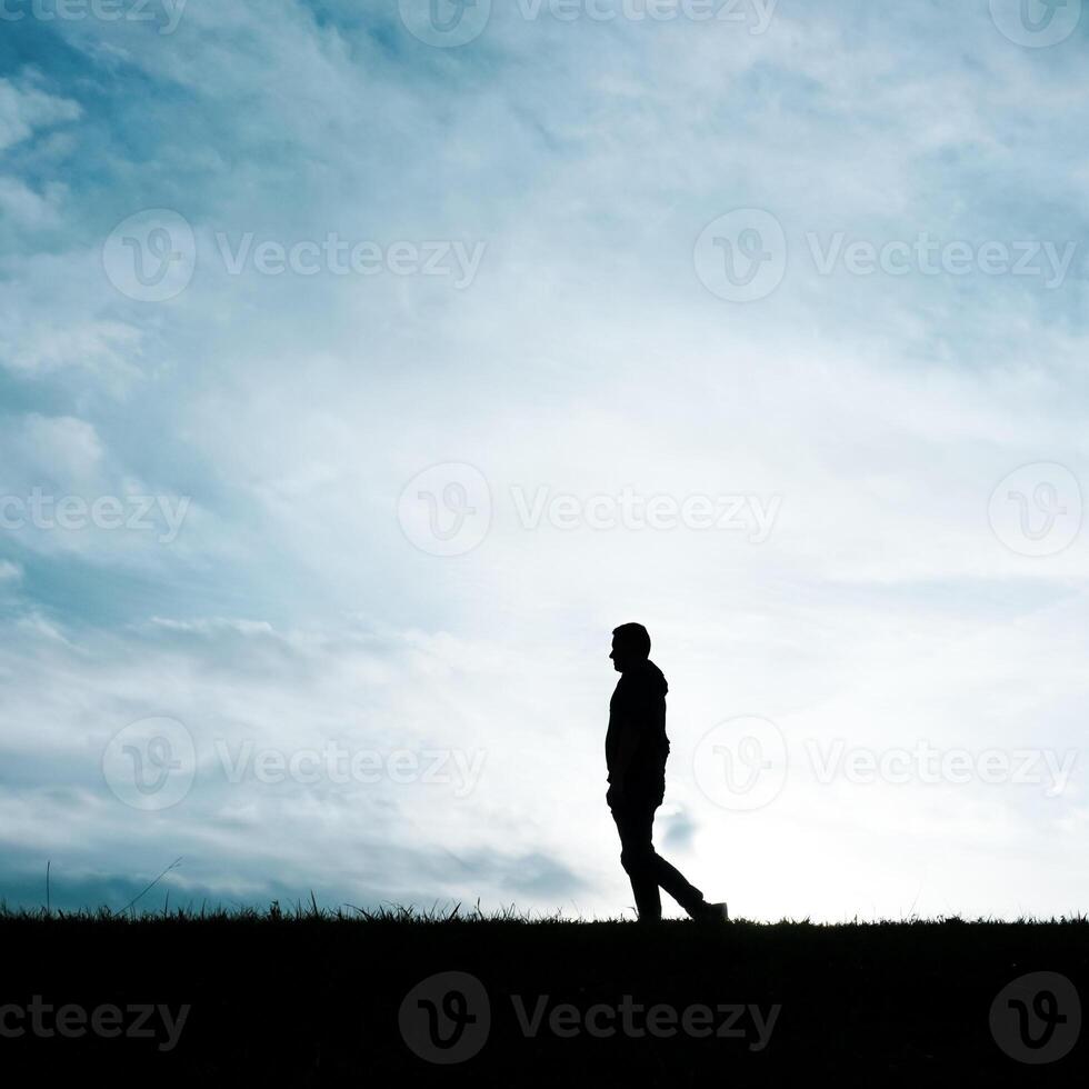 hombre silueta en el campo en el verano y puesta de sol antecedentes foto