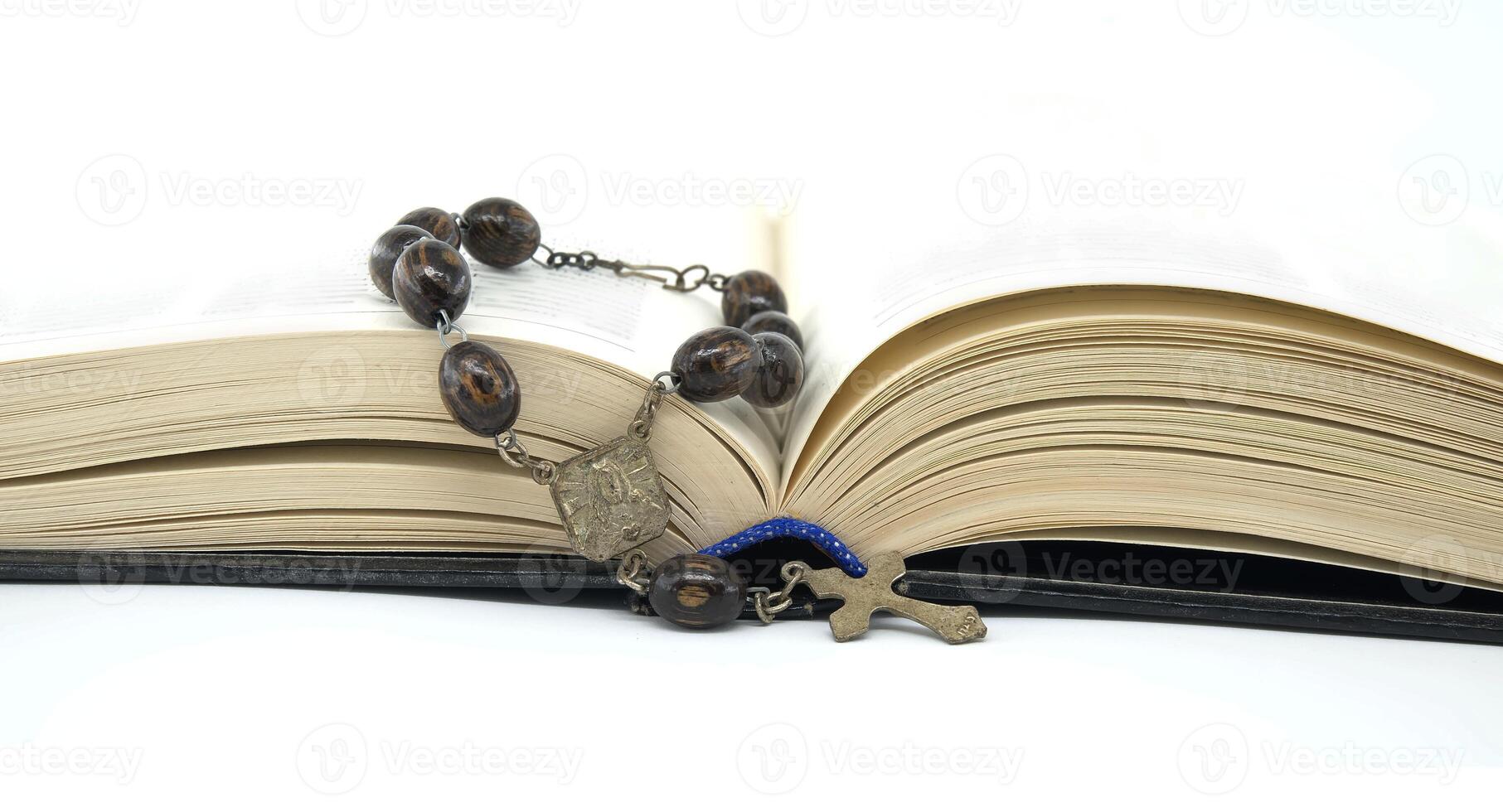 Open book placed against white background with rosary photo