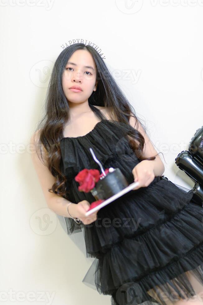 Beautiful woman wearing a black dress and chocolate cake in the concept of birthday photo