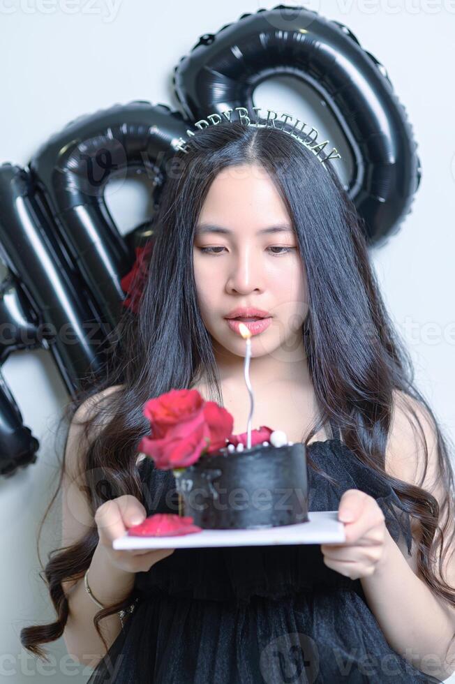 hermosa mujer vistiendo un negro vestir y chocolate pastel en el concepto de cumpleaños foto