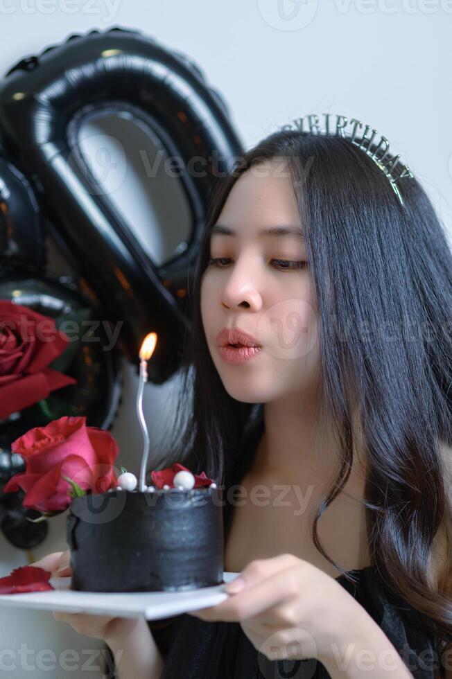 Beautiful woman wearing a black dress and chocolate cake in the concept of birthday photo