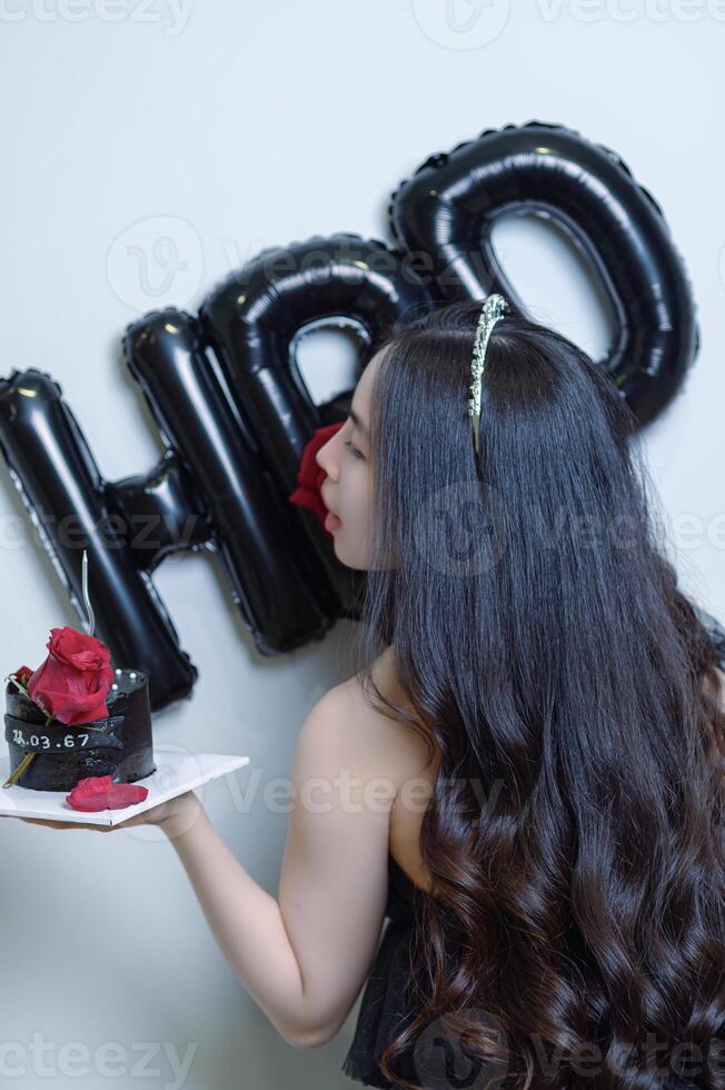 hermosa mujer vistiendo un negro vestir y chocolate pastel en el concepto de cumpleaños foto