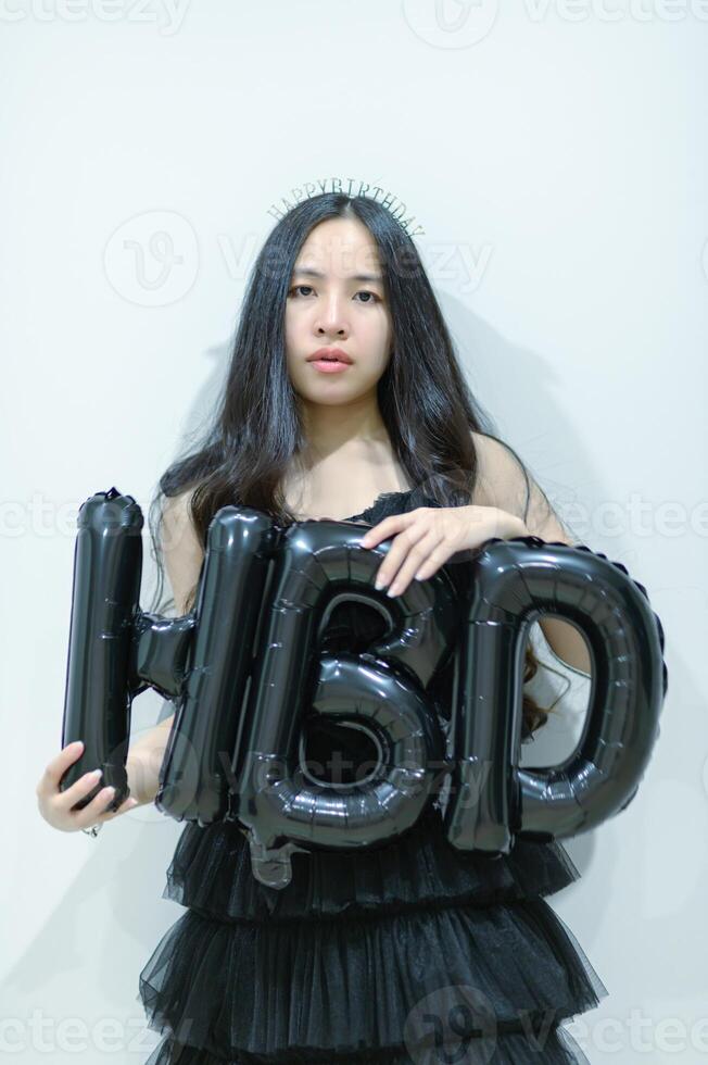 Beautiful woman wearing a black dress and chocolate cake in the concept of birthday photo