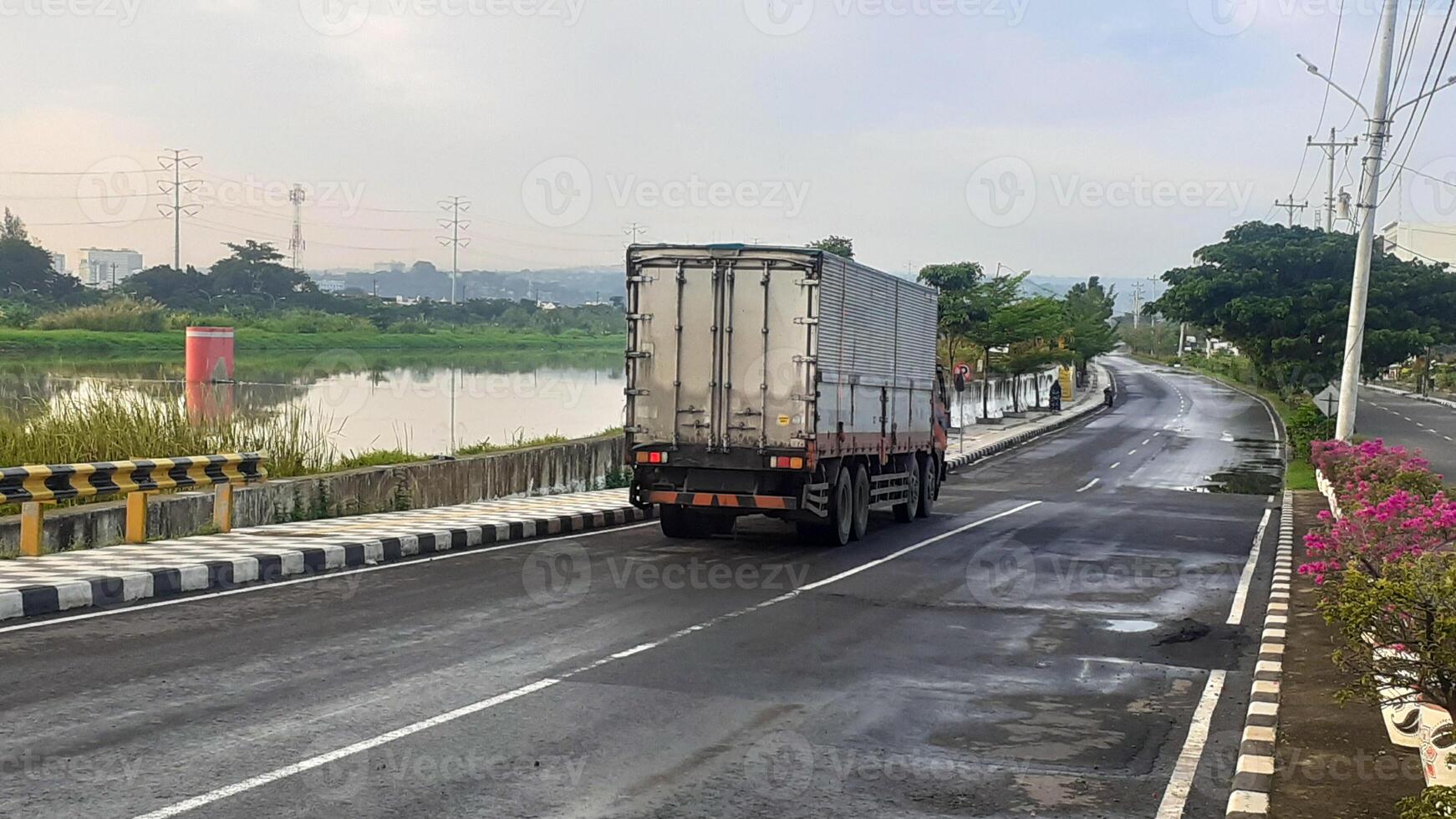 A large box truck passes by on a quiet road photo