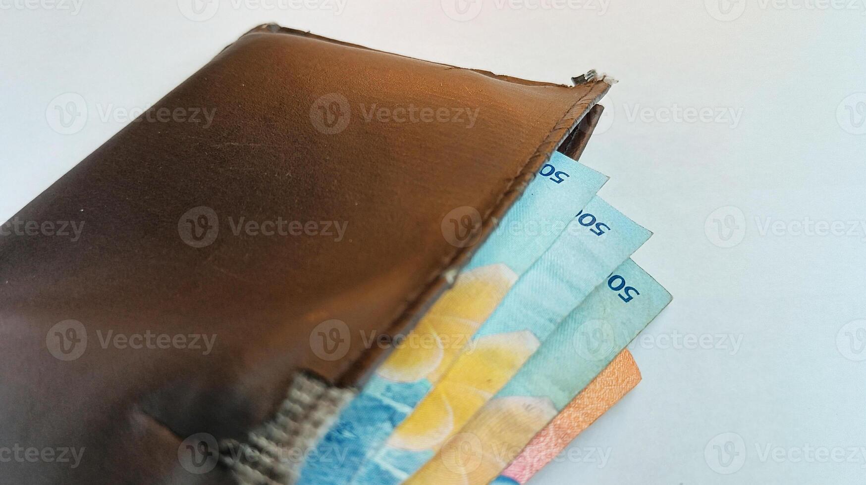 close up brown wallet filled with money photo