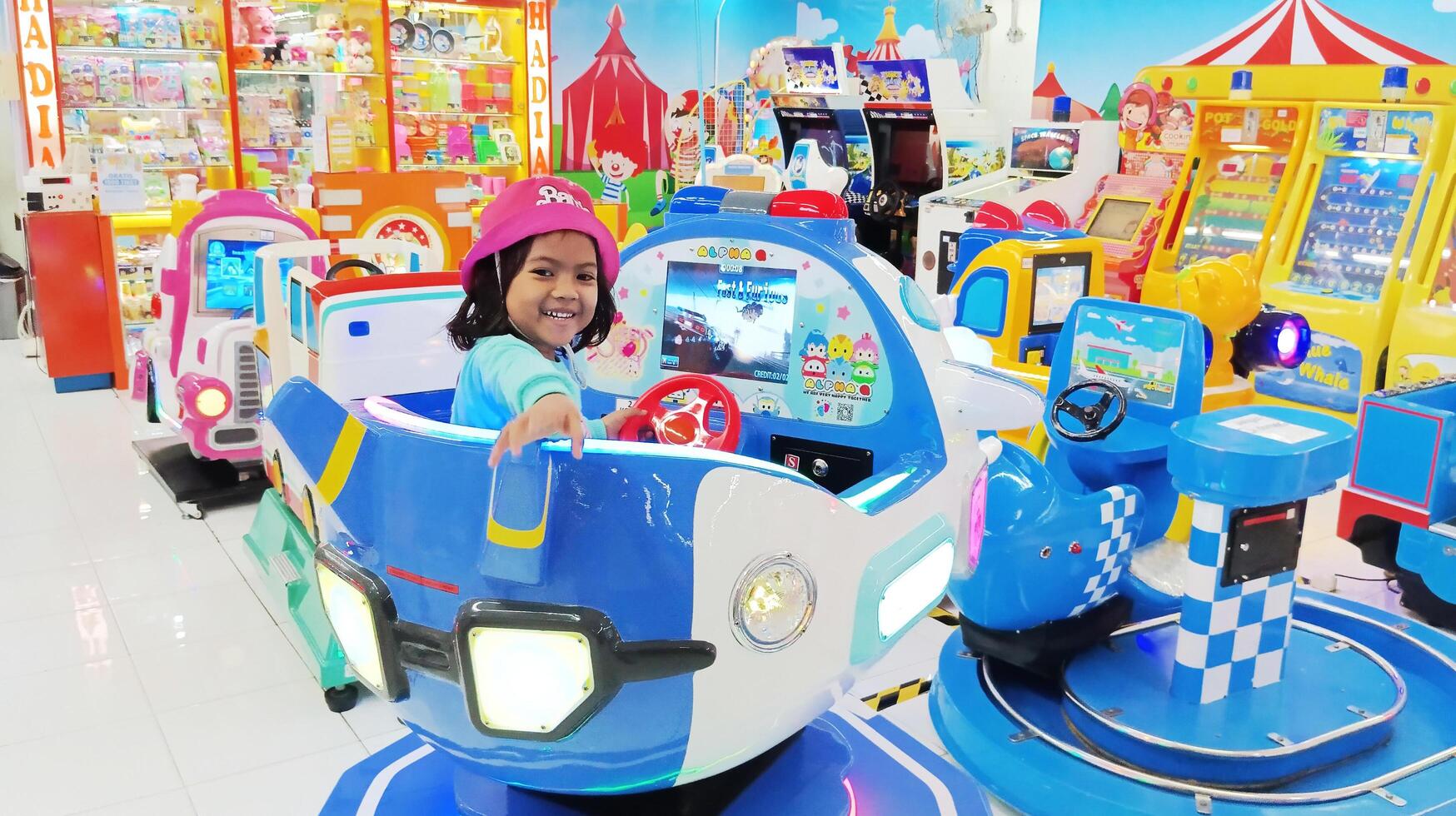 Semarang, Indonesia - February 7, 2024 - A little girl riding a plane game on the playground, little girl playing photo