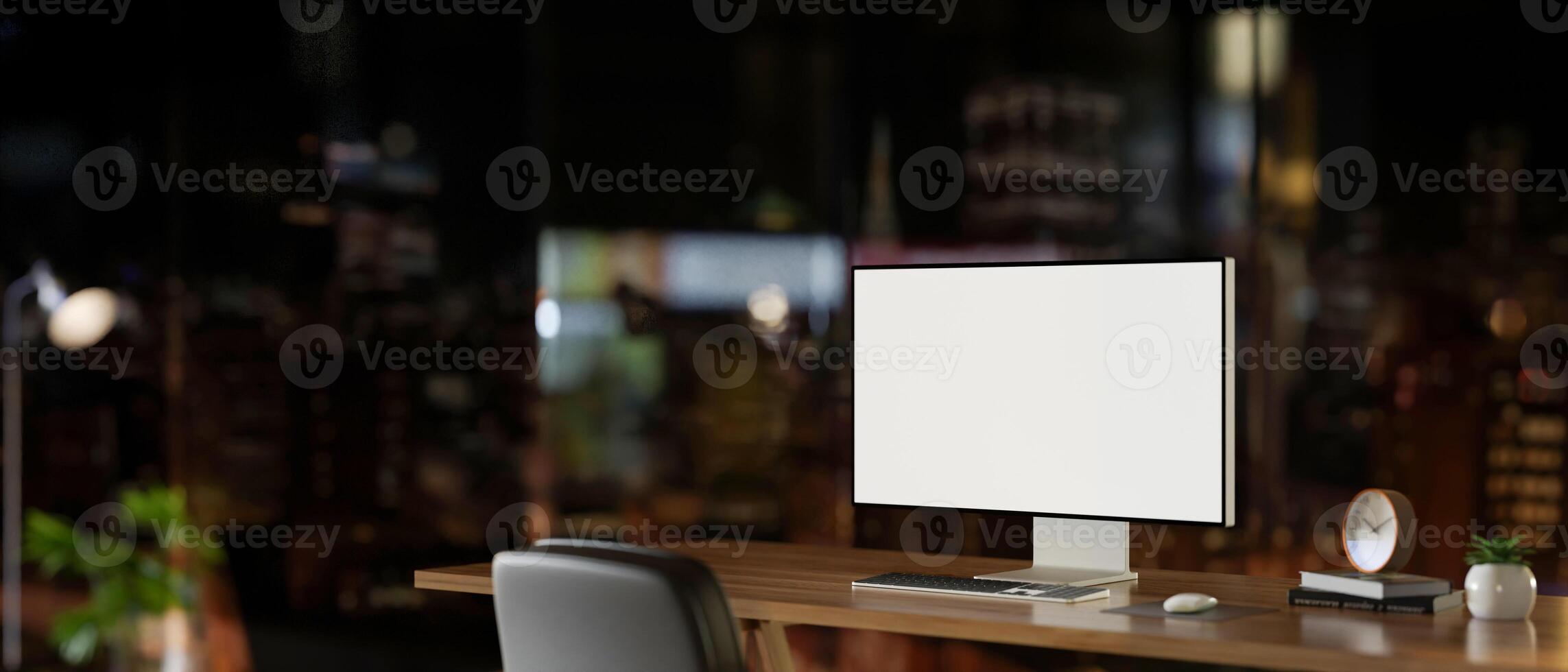 A contemporary skyscraper office at night features a white-screen computer mockup on a wooden desk. photo