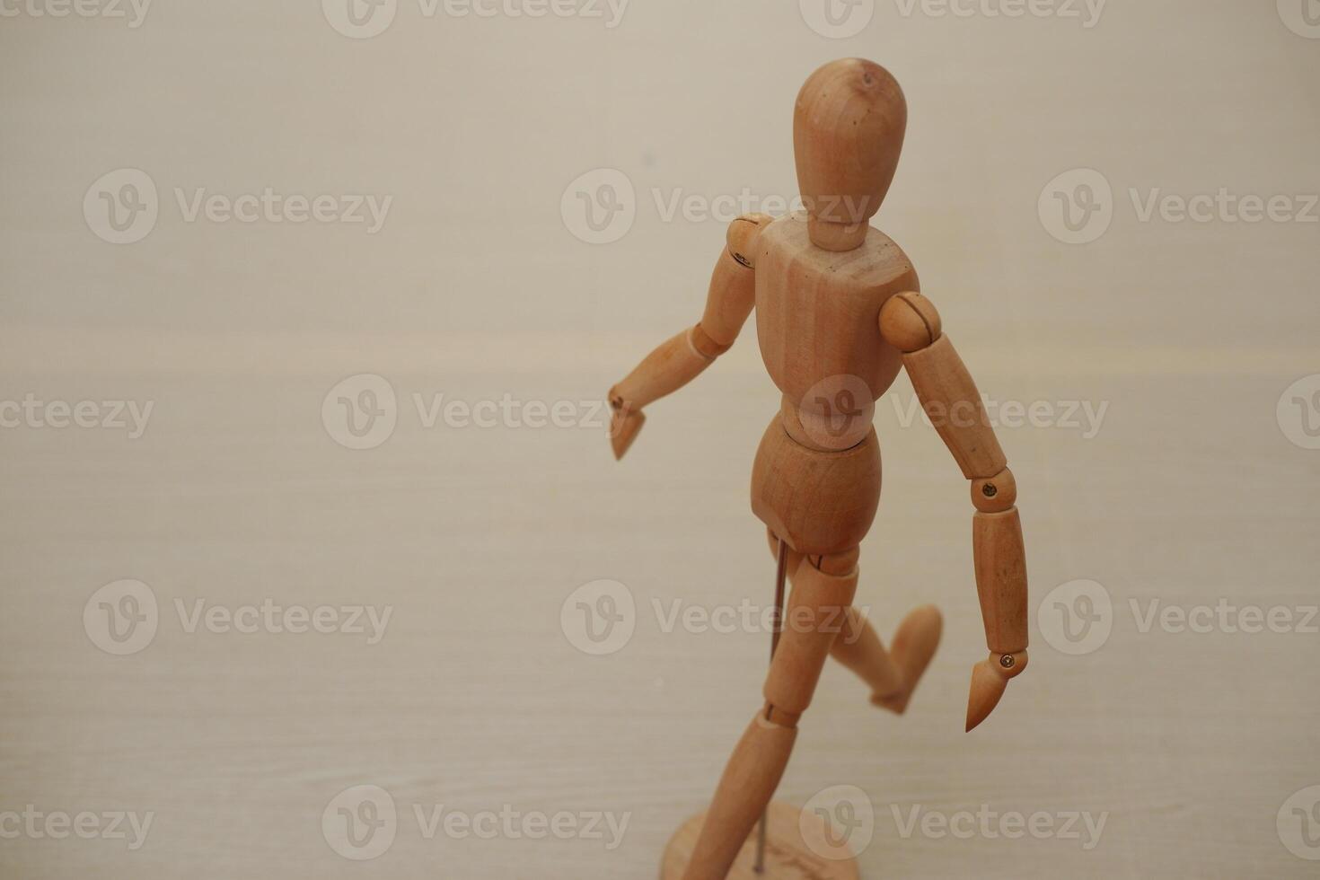 Wooden mannequin standing on a wooden background. Selective focus. photo