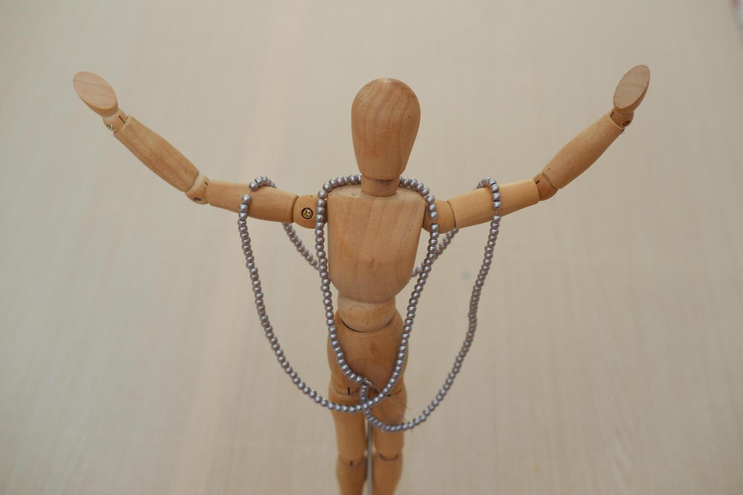 Wooden mannequin with necklaces and beads on a wooden background photo