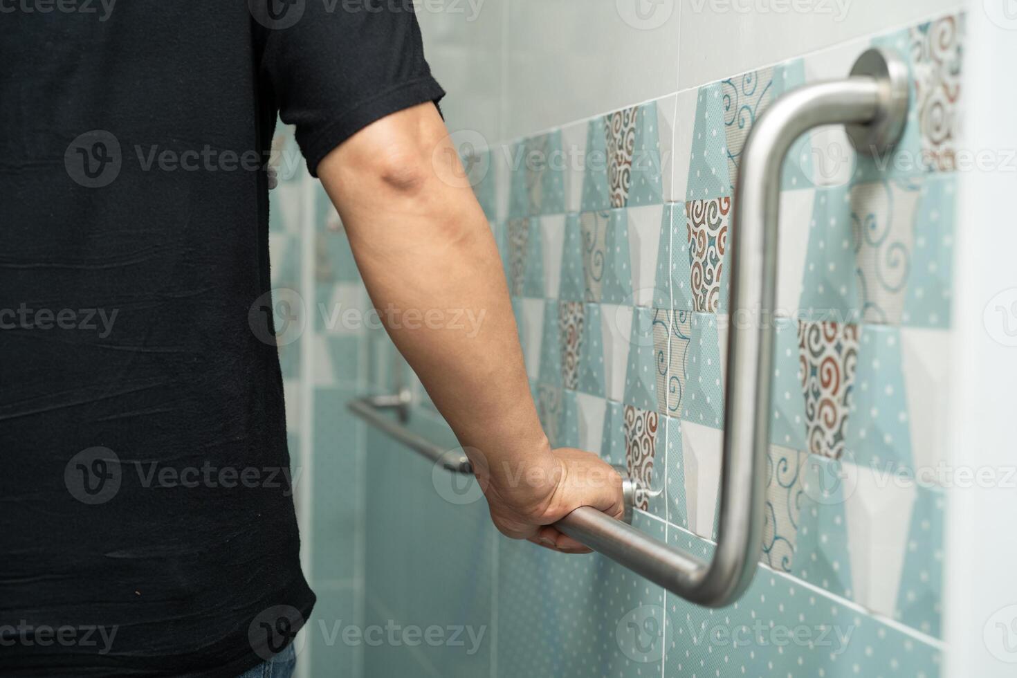 Asian elderly woman patient use toilet bathroom handle security in nursing hospital, healthy strong medical concept. photo