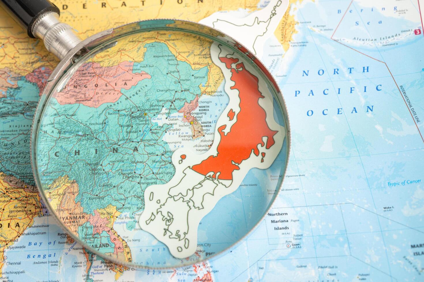 Bangkok, Thailand  January 20, 2022 Japan, Magnifying glass close up with colorful world map, travel, geography, tourism and exploration. photo